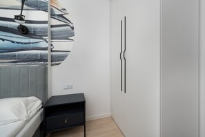 Ein Schlafzimmer mit einem Bett, einem Nachttisch, einer Wandleuchte und einem Kleiderschrank.