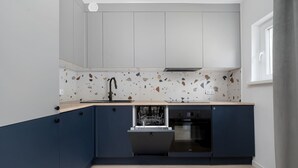 Una cucina compatta con lavastoviglie, lavello e finestra.