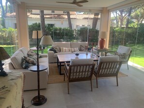 A sunlit patio with a sofa, chairs, a table, and a lamp. - Villa with a pool and a 1,800-meter lot in the Roche Development (Roche)