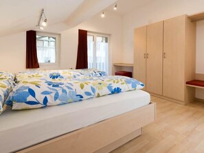 Un dormitorio con cama, escritorio y armario.