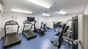 Ett träningsrum med löpband, crosstrainers och styrketräningsutrustning.