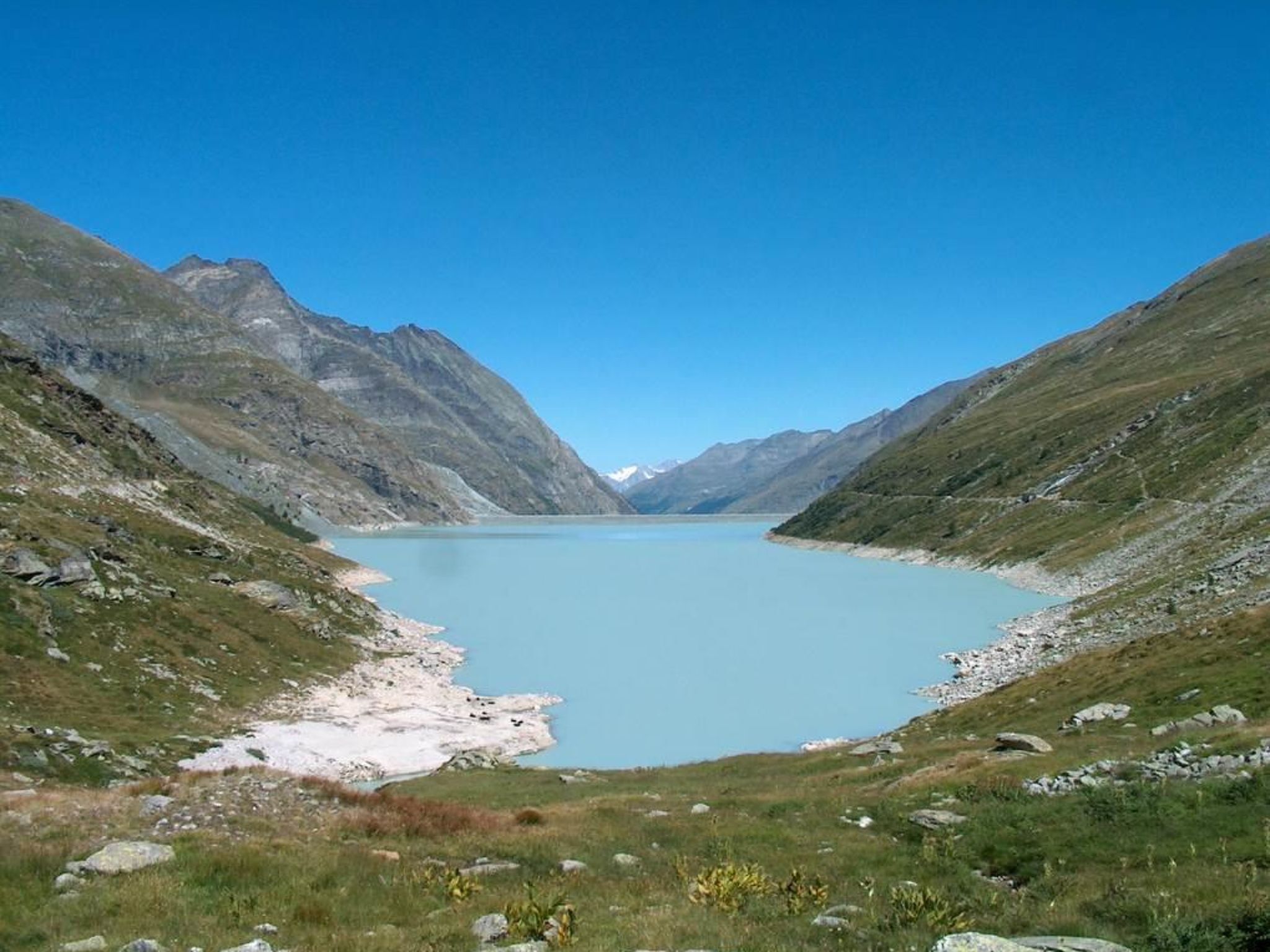 Un lago de montaña rodeado de terreno rocoso.