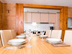 A dining room with a wooden table set for six, including plates, glasses, and cutlery. - Chalet Alpenrösli Appartement/Fewo Alpenrösli 7-Bettwohnung Nr. 7 by Interhome (Saas-Almagell)