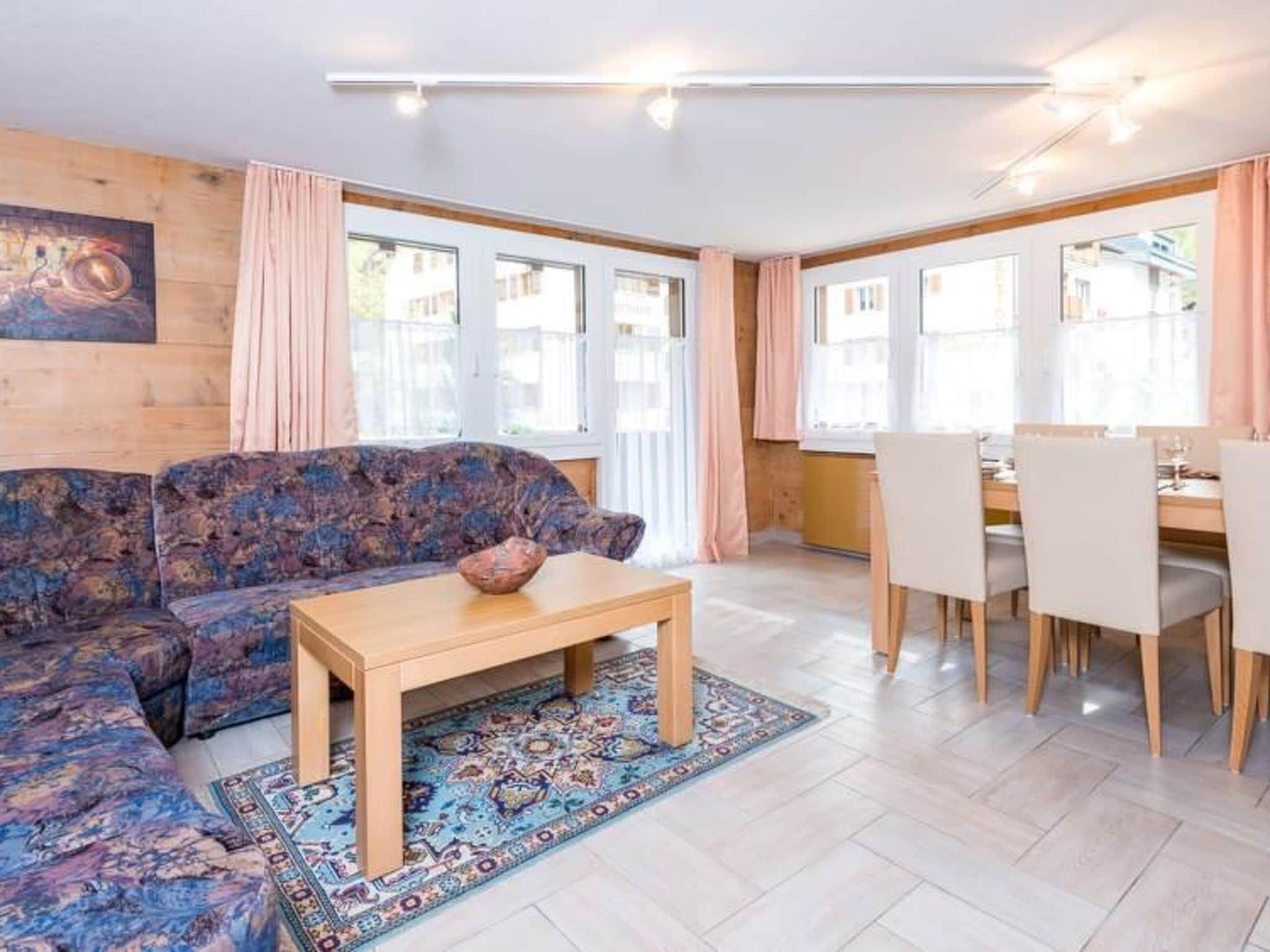 Ein Wohnzimmer mit einer Couch, einem Couchtisch und einem Essbereich mit Stühlen und einem Tisch.