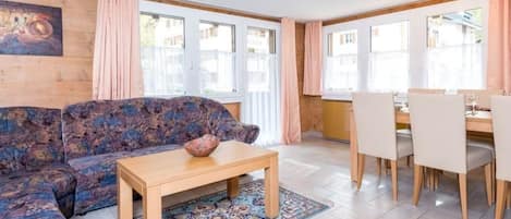 Ein Wohnzimmer mit einer Couch, einem Couchtisch und einem Essbereich mit Stühlen und einem Tisch.