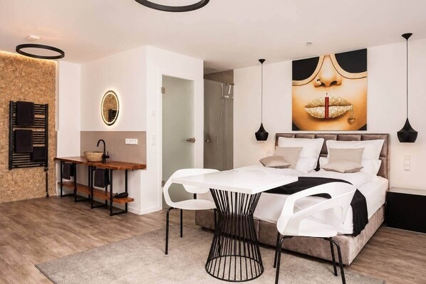 A modern bedroom with a bed, bedside table, and a large wall art piece.
