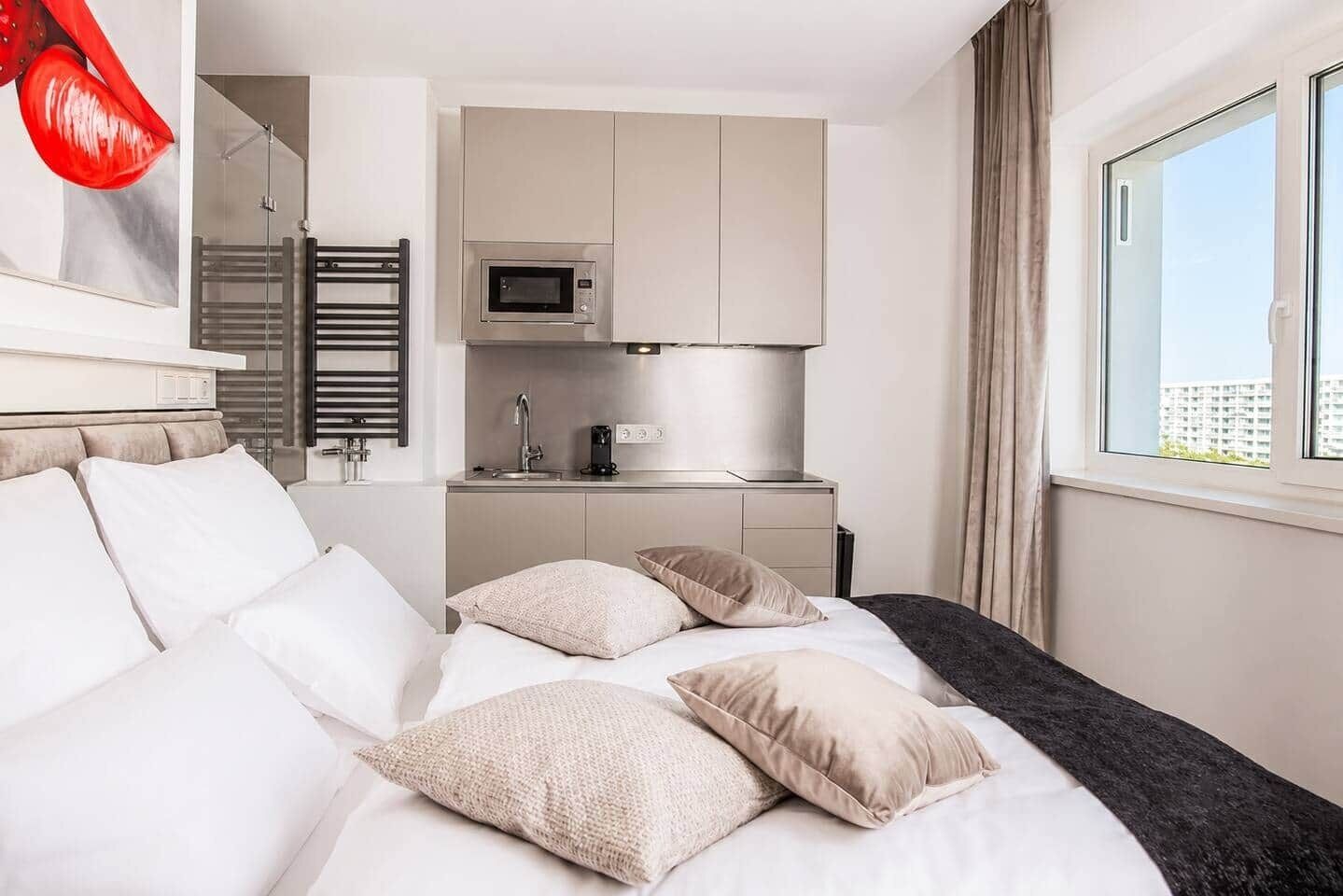 Ein Hotelzimmer mit einem Bett, einer kleinen Küchenzeile und einem Fenster mit Blick.