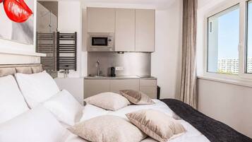Ein Hotelzimmer mit einem Bett, einer kleinen Küchenzeile und einem Fenster mit Blick.