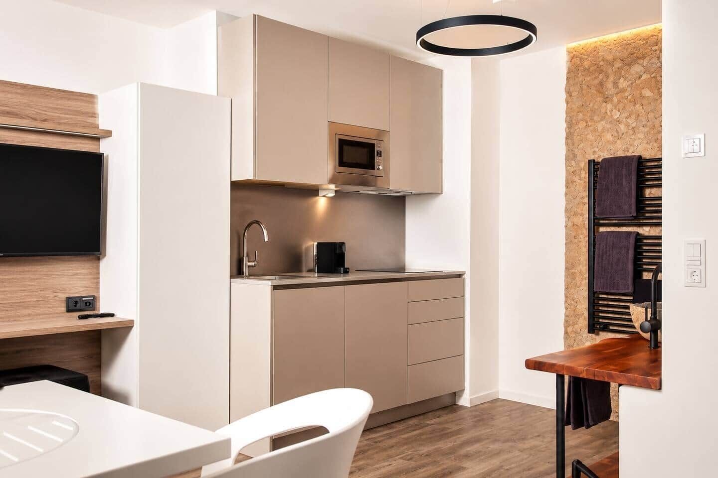 Eine moderne Küche mit integriertem Mikrowellenherd, einer Kaffeemaschine und einem Spülbecken.