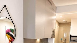 A compact kitchen with a modern design, featuring a built-in sink and a microwave. - The Faces | Premium Studio | Balcony | 203 (Berlin)