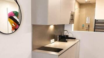 Eine kompakte Küche mit modernem Design, ausgestattet mit einer eingebauten Spüle und einer Mikrowelle.