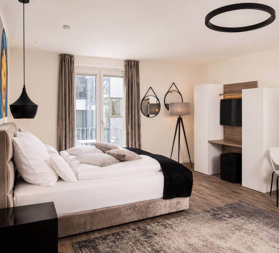 Ein modernes Schlafzimmer mit einem großen Bett, einem Schreibtisch und einem Kleiderschrank.