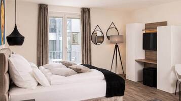 Ein modernes Schlafzimmer mit einem großen Bett, einem Schreibtisch und einem Kleiderschrank.