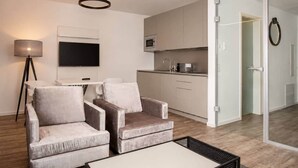 Ein modernes Wohnzimmer mit einer Couch, einem Couchtisch und einem Flachbildfernseher.