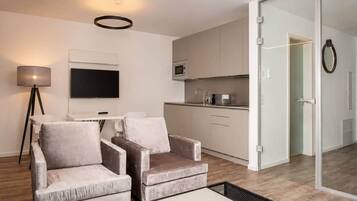 A modern living room with a sofa, a coffee table, and a flat-screen TV.