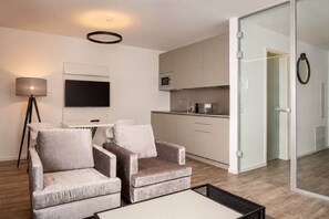 Ein modernes Wohnzimmer mit einer Couch, einem Couchtisch und einem Flachbildfernseher.