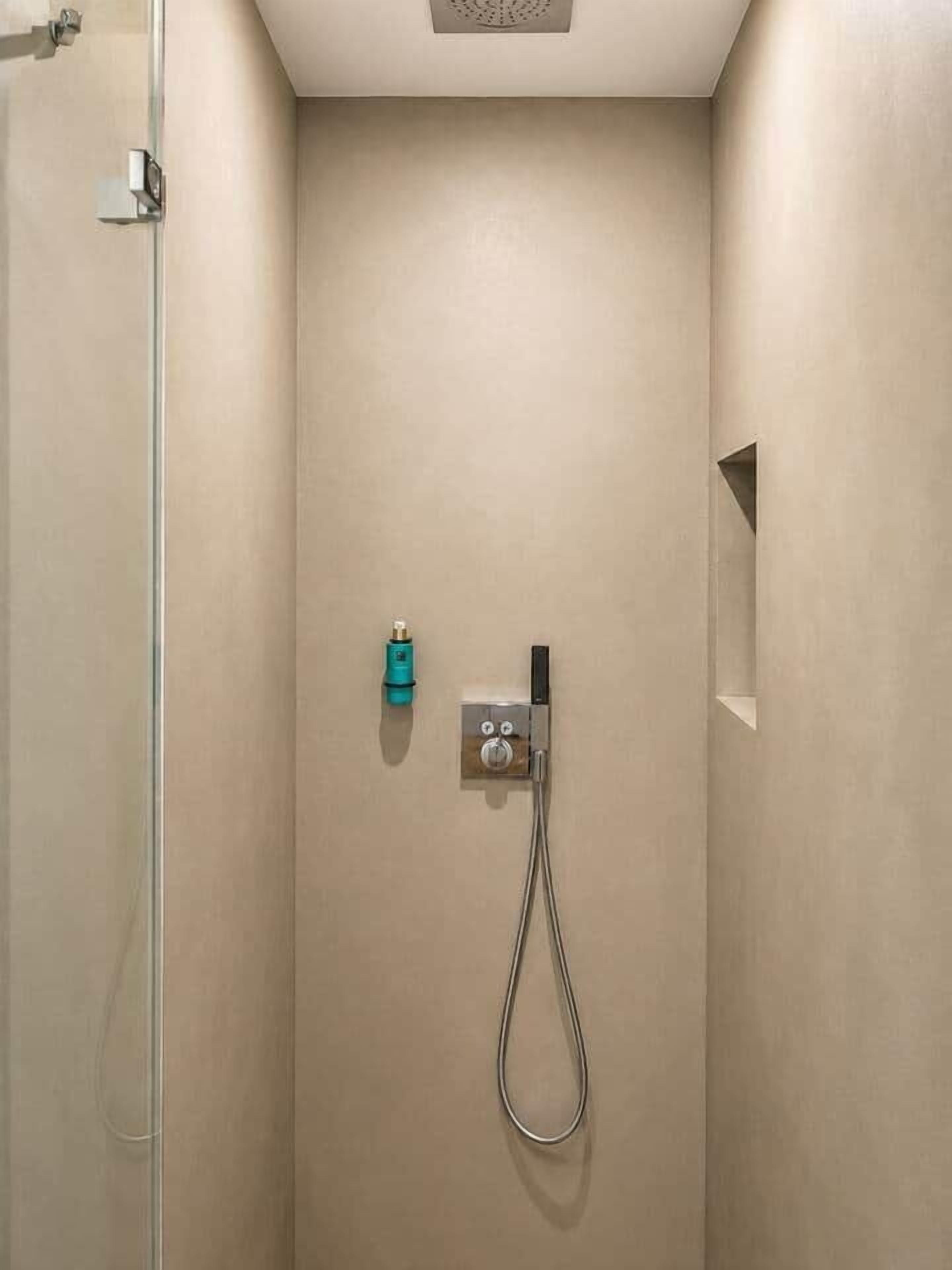 Eine Dusche mit Handbrause und Bedienfeld.