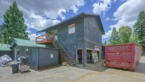 A two-story building with a balcony, a staircase, and a red dumpster. - Walk to Ski Lifts! Apt in Heart of Red River (Red River)