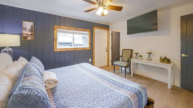 A bedroom with a bed, a chair, a TV, a ceiling fan, and a window. - Walk to Main St: Red River Lodge w/ Ski Views! (Red River)