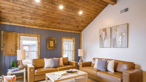 A cozy living room with a wooden ceiling, two leather sofas, a coffee table, and two wall-mounted lamps. - Walk to Main St: Red River Lodge w/ Ski Views! (Red River)