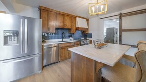 A modern kitchen with stainless steel appliances, wooden cabinets, and a marble countertop. - Walk to Main St: Red River Lodge w/ Ski Views! (Red River)