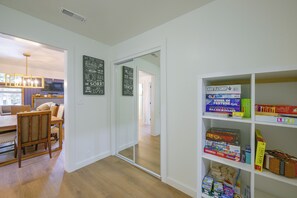 A room with a dining area, a bookshelf with board games, and a sliding glass door leading to another room. - Walk to Main St: Red River Lodge w/ Ski Views! (Red River)