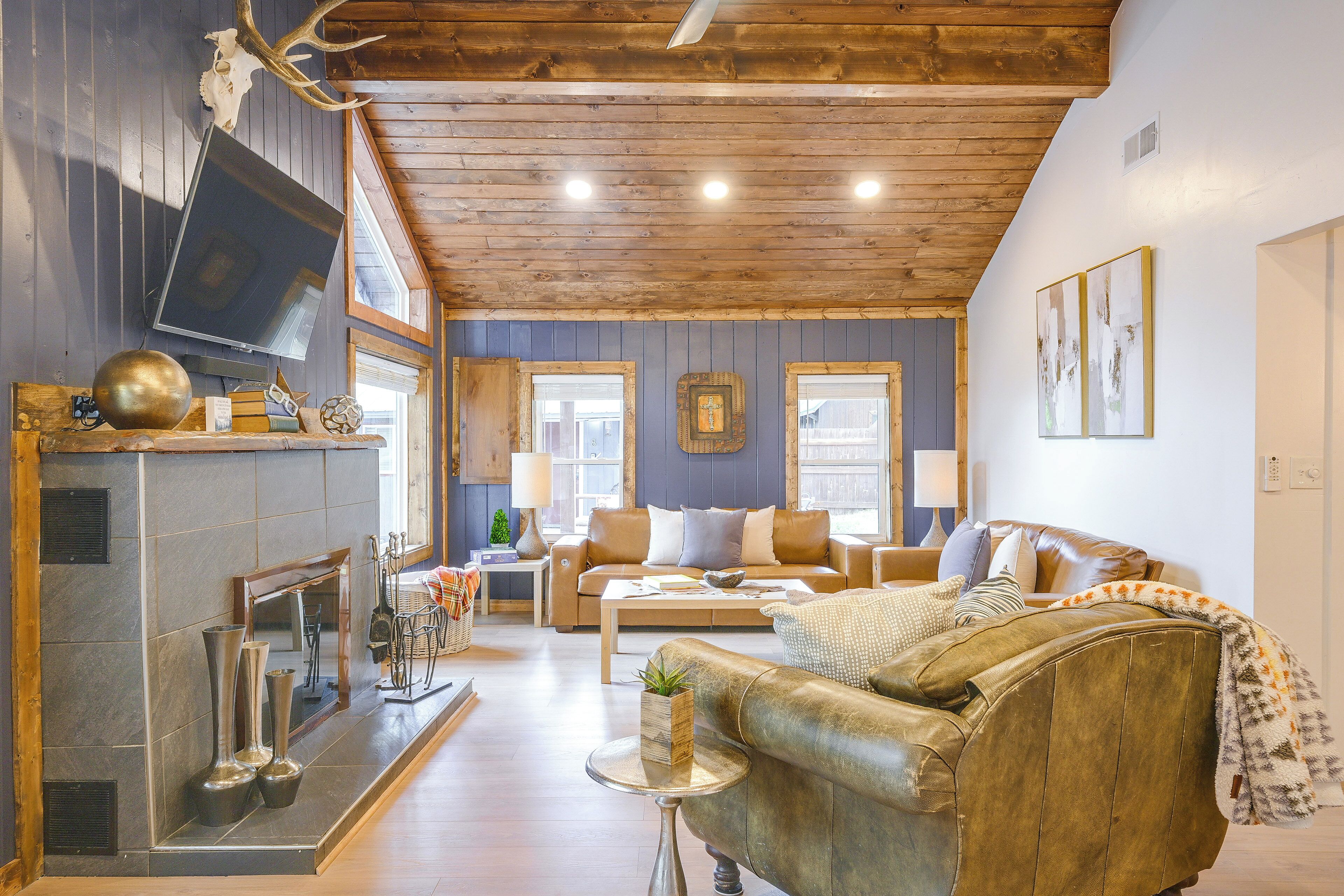 Una sala acogedora con chimenea, sofá de cuero y televisor.
