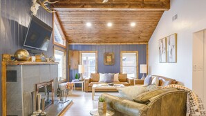 A cozy living room with a fireplace, leather sofa, and a television. - Walk to Main St: Red River Lodge w/ Ski Views! (Red River)