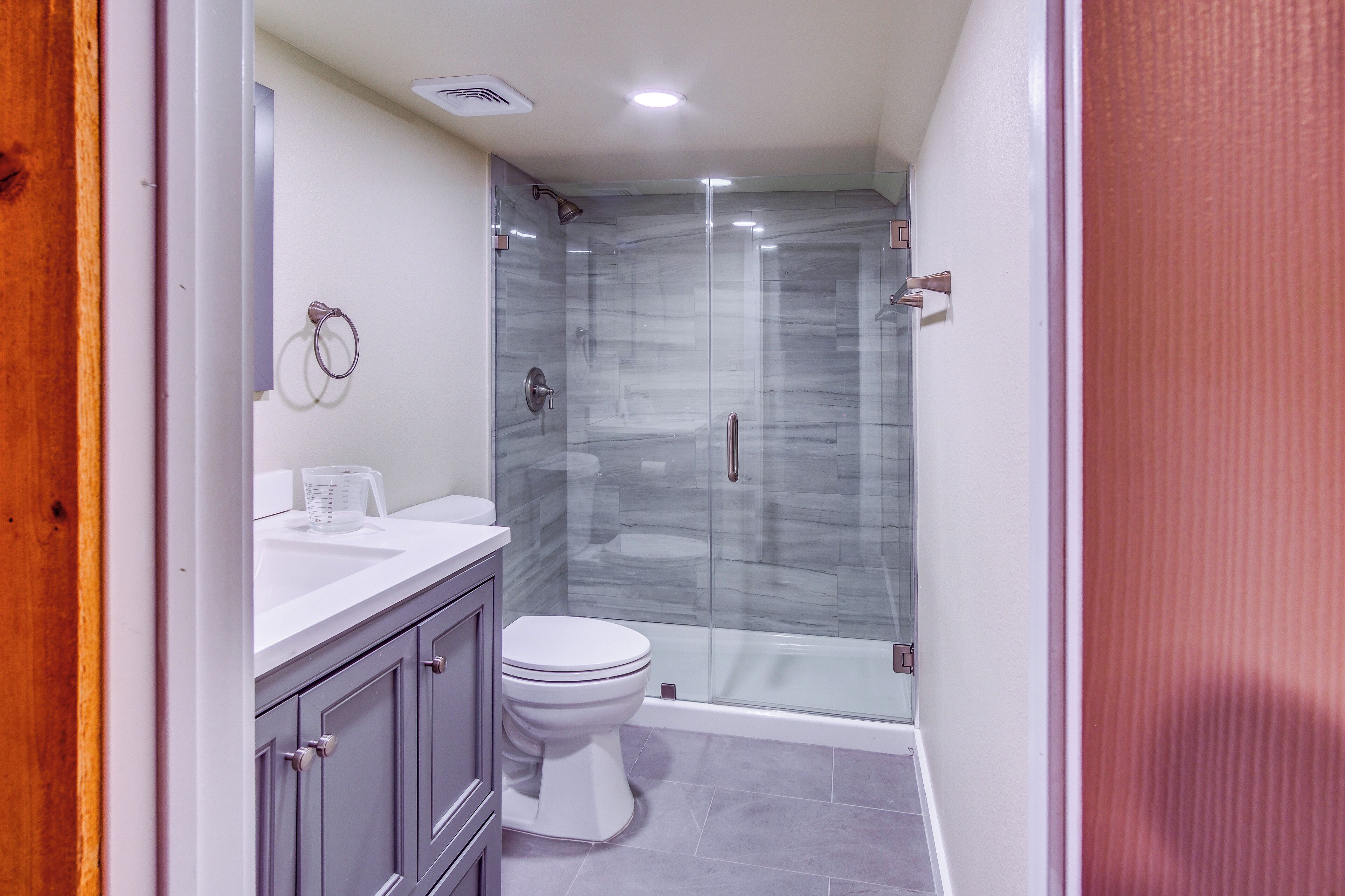 A bathroom with a shower, toilet, and vanity.