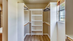 A walk-in closet with wooden flooring and white shelving units. - Gated Ranch Retreat Near Lakes & Frisco (Aubrey)