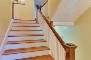 A staircase with wooden steps and a wooden handrail, leading to a landing with a white textured ceiling. - Walk to Beach & Oceanside Trails! Family Retreat (York Harbor)