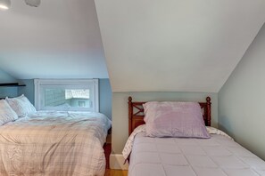 A bedroom with two beds, a window, and a sloped ceiling. - Walk to Beach & Oceanside Trails! Family Retreat (York Harbor)