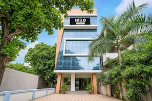 A modern hotel building with a sign that reads 'HOTEL' and 'YO-Serviced'.