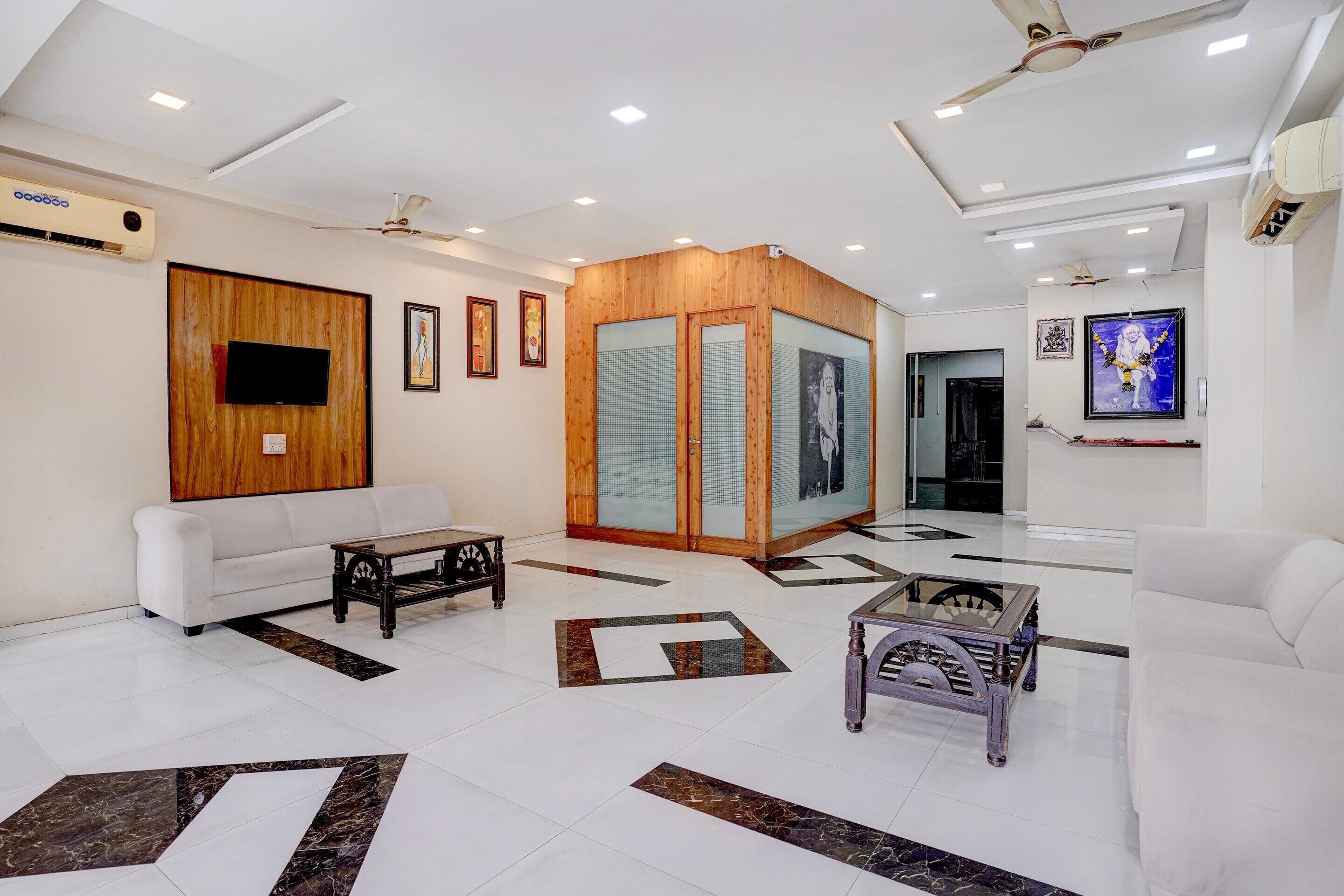 A modern reception area with a white sofa, a wooden partition, and a tiled floor with geometric patterns.