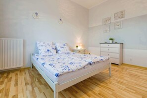 Ein Schlafzimmer mit Bett, Nachttisch, Lampe, Kommode und Wanddekorationen.