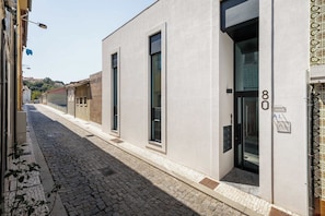 Ein Gebäude mit einer modernen Fassade, großen Fenstern und einer Kopfsteinpflasterstraße.