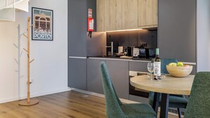 Una cocina moderna con comedor, perchero y un cuadro en la pared.