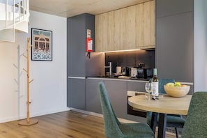 Eine moderne Küche mit Essbereich, Kleiderhaken und einem gerahmten Bild an der Wand.