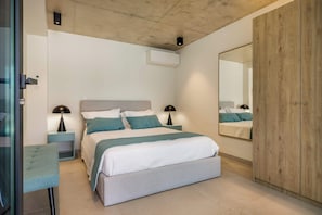 Ein modernes Schlafzimmer mit Bett, Nachttischen, einem Spiegel und einem Kleiderschrank.
