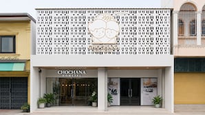 A hotel named Chochana with a modern facade, a decorative lattice front, and a sign indicating it is a homestay.