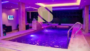 Una piscina con muelle de madera y escalera metálica.
