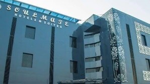 Un edificio de hotel con un diseño moderno, que presenta un letrero llamativo que dice 'SOULMASE HOTELS & SUIITES'.