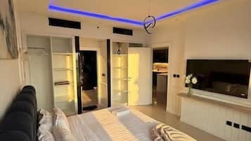 A modern bedroom with a bed, a TV, and a wardrobe.