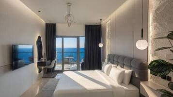 Una habitación de hotel moderna con una cama grande, un televisor de pantalla plana, un balcón con vistas y un comedor.