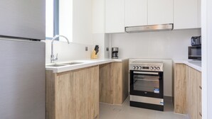 A compact kitchen with a built-in oven, a coffee maker, and a microwave. - Bloomfields 2BRplus Maid in Noya Viva  (Abu Dhabi)