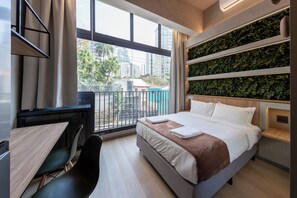 A modern hotel room with a large bed, a desk, and a view of the city. - Aimbere by Bhomy (São Paulo)