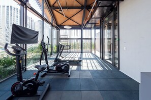 A gym with exercise equipment and large windows. - Aimbere by Bhomy (São Paulo)