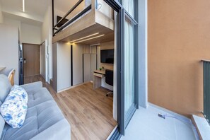 Un interior modern amb un sofà, una zona de dinar i una cuina.