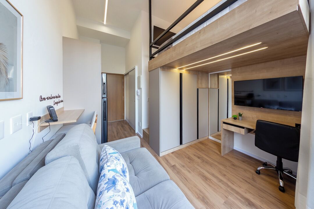 Un espace de vie moderne comprenant un canapé, un bureau et un téléviseur.