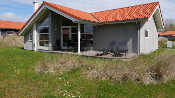 A modern house with a red-tiled roof, large windows, and a covered patio area. - Grobenbrode Kustenurlaub (Grossenbrode)